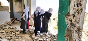 Flickor i Jemen på väg ut ur en ruin.