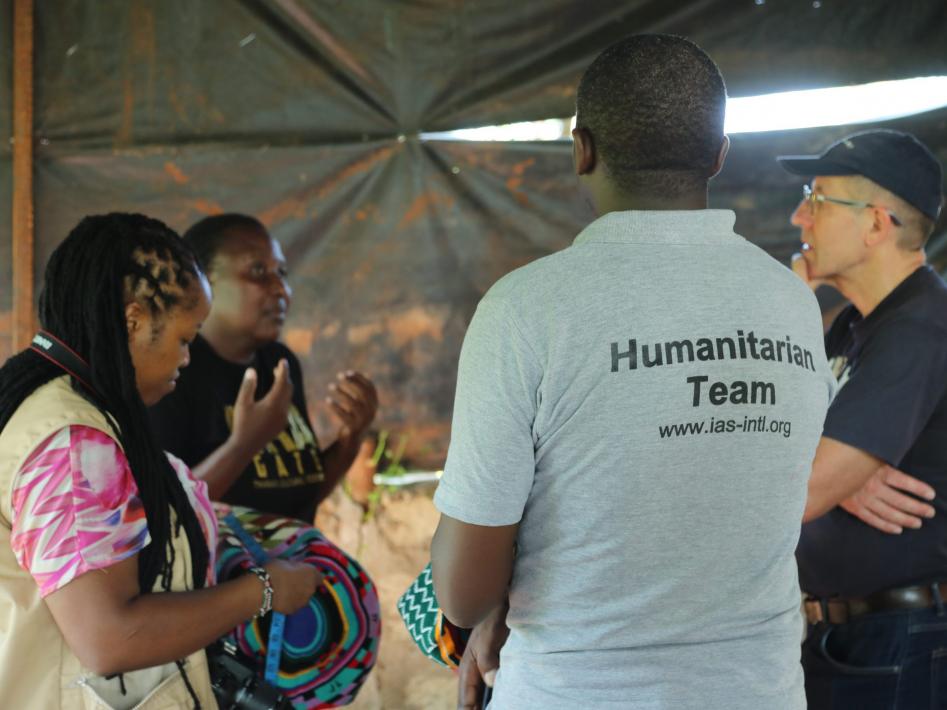 Ett samtal på humanitär konferens i Kenya 2020. Några personer i samtal där en står med ryggen mot fotografen och på hans tröja står det Humanitarian Team.