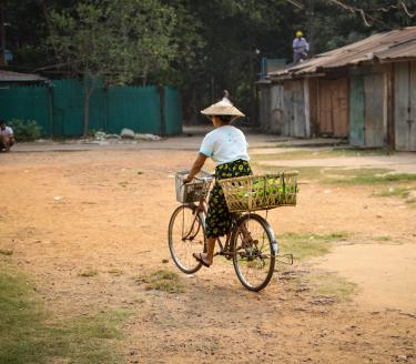 Foto-Magdalena-Vogt-2022-Kvinna-pa-cykel-Yangon-Myanmar-scaled-aspect-ratio-947-710