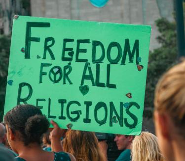Demonstration i USA för religionsfrihet. En grön skylt med texten Freedom for all religions vid en demonstration i USA.