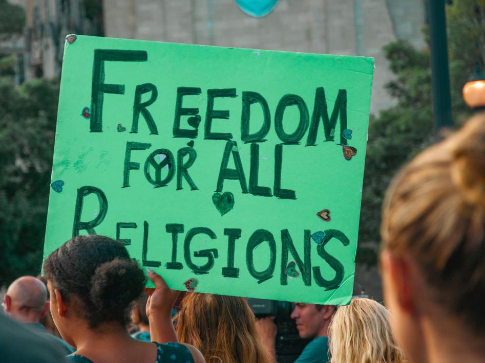 Demonstration i USA för religionsfrihet. En grön skylt med texten Freedom for all religions vid en demonstration i USA.